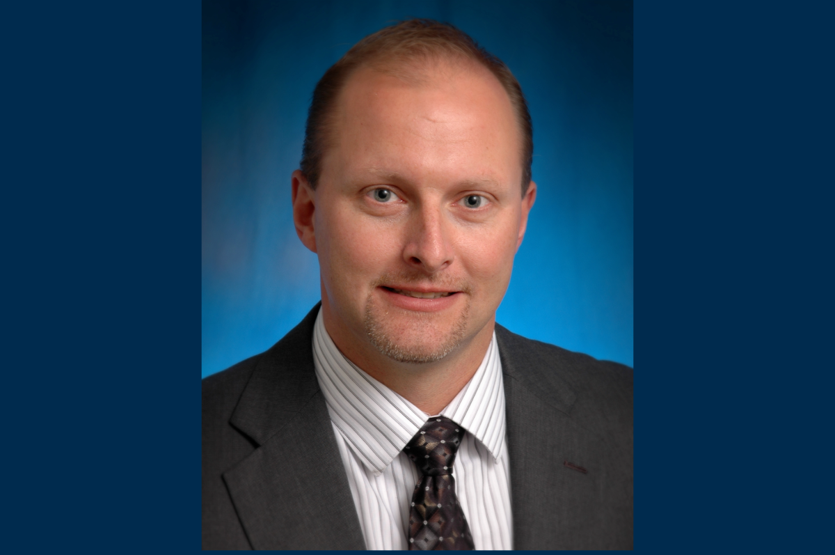 Portrait of man in brown jacket and striped shirt